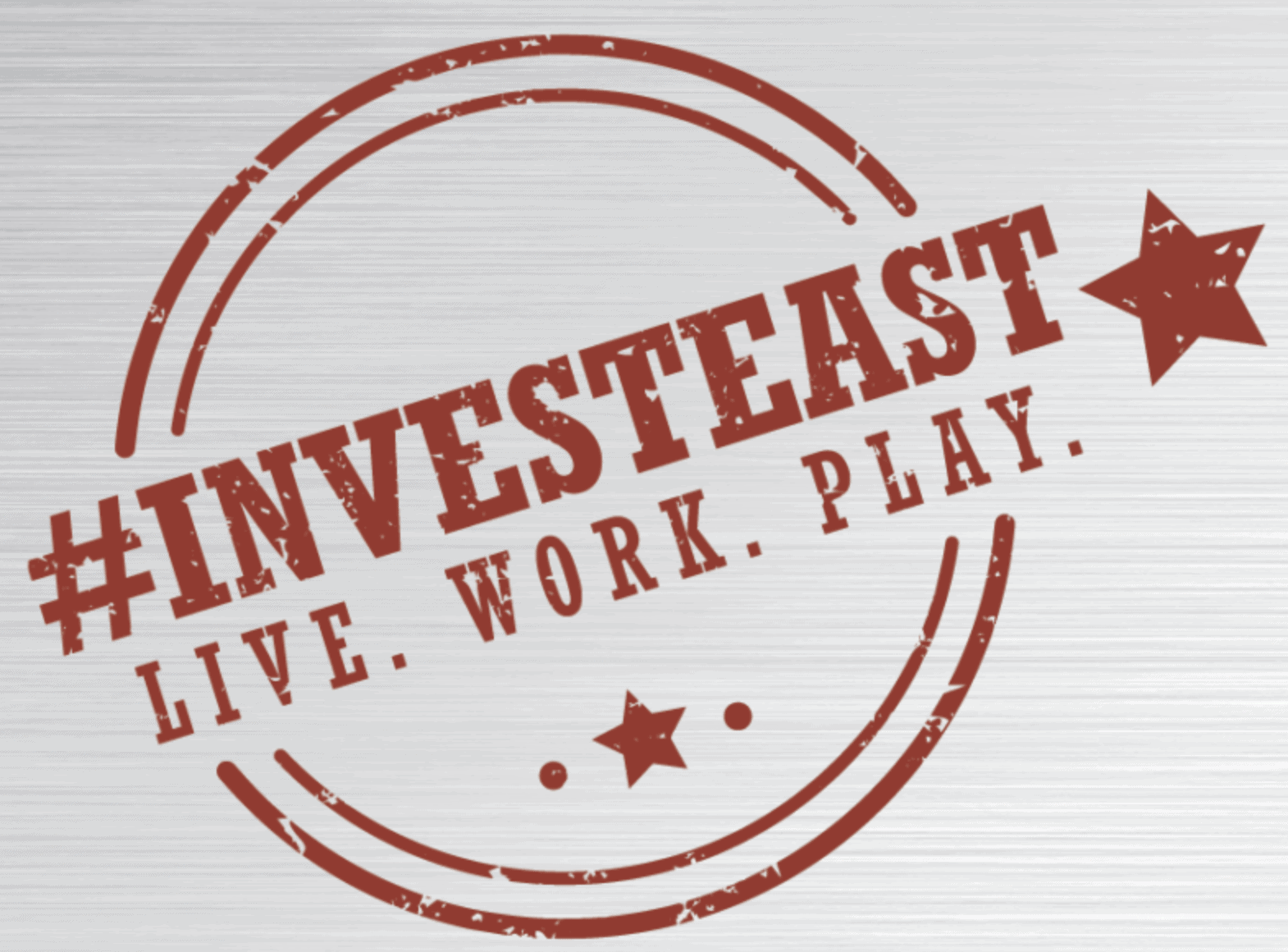 Red circle and star graphics with text reading "#INVESTEAST Live. Work. Play"